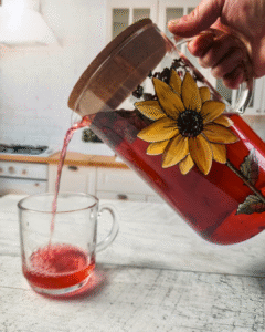Une infusion froide versée d'un pichet en verre dans une tasse